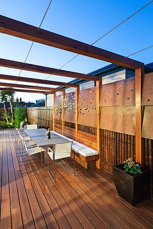 Timber pergola with dining table and laser-cut corten steel privacy screens in Hawthorn East courtyard garden