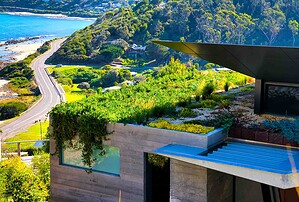 Tiered corten steel retaining walls creating outdoor living spaces on steep coastal site at Separation Creek