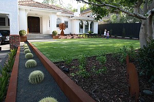 Modern front garden with corten steel edging, barrel cacti, and lawn at Malvern East family home