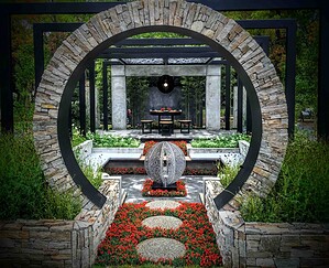 Circular stone moon gate frames formal garden with sculptural water feature and pavilion seating area in Nagasaki Japan