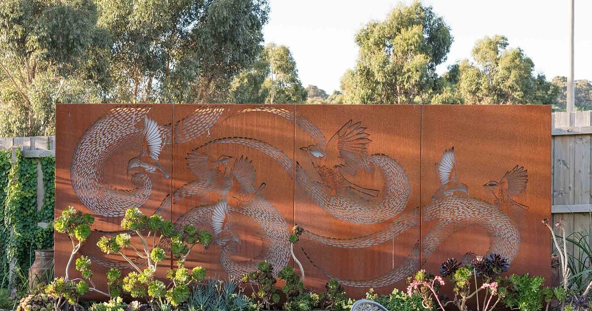 Laser-cut corten steel wattle birds panels against native garden plantings in Buninyong residential landscape design