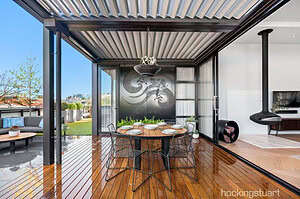 Modern rooftop terrace with blackbutt decking, steel pergola, and outdoor dining area overlooking St Kilda cityscape