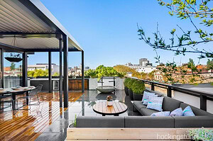Modern rooftop terrace with blackbutt timber decking, grey outdoor lounge seating and city views in St Kilda