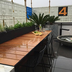 Outdoor kitchen with blackbutt timber countertop and black cabinetry on St Kilda rooftop terrace with screening and plants