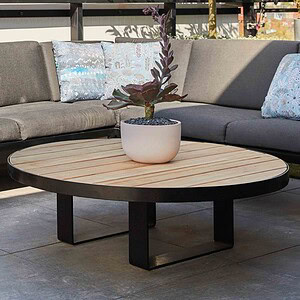 Grey outdoor sectional sofa with patterned cushions and round timber coffee table with succulent plant on St Kilda rooftop