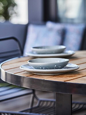 Custom timber dining table with ceramic tableware on St Kilda rooftop terrace from The Block