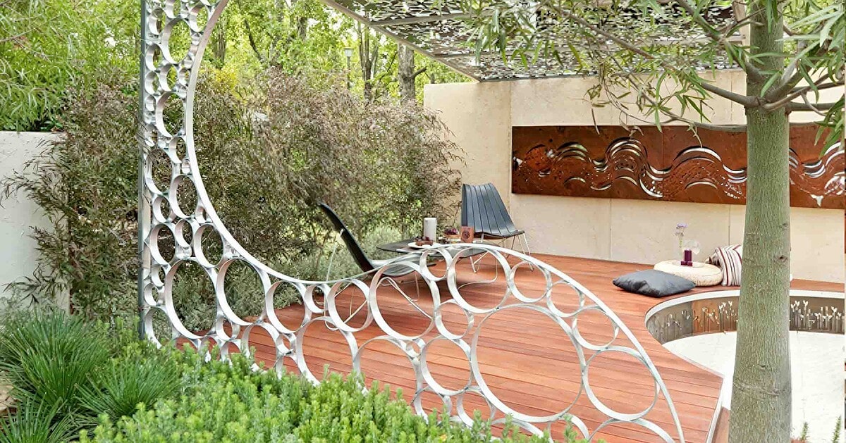 Circular steel garden structure with organic perforations framing pathway in modern landscape design