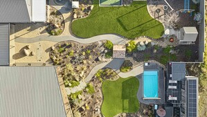 Aerial view of contemporary pool garden with curved exposed aggregate paths, native plantings and lawn areas in Gisborne