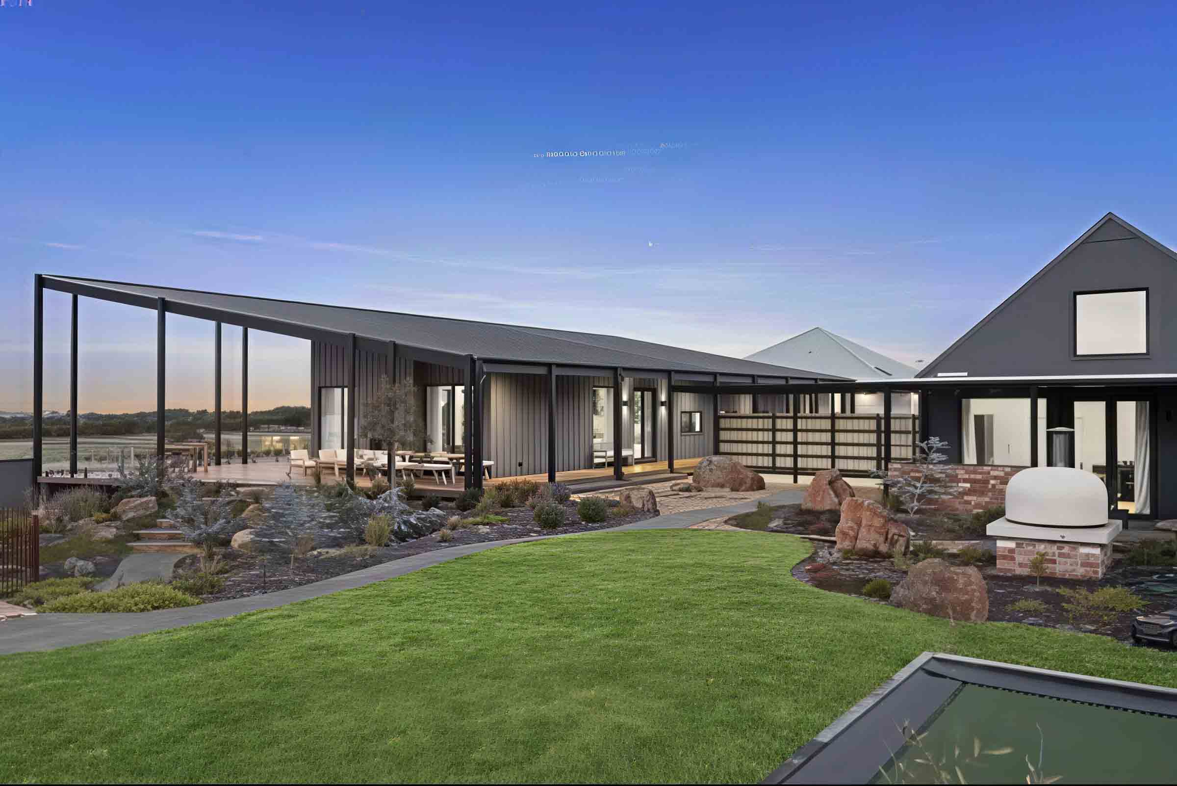 Modern single-story home with curved exposed aggregate paths connecting deck to pool area in Gisborne country garden