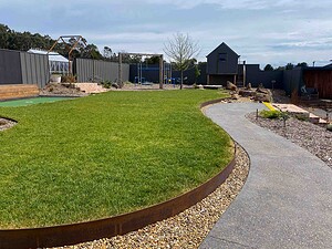 Curved exposed aggregate pathways winding through open lawn areas in Gisborne Macedon Ranges country garden design