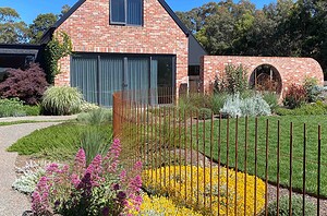 Custom steel rod pool fence with vertical bars creating safety barrier around garden beds in Mount Buninyong country estate