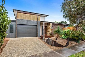 Contemporary single-story home with mixed material facade featuring timber screens, stone cladding, and native landscaping